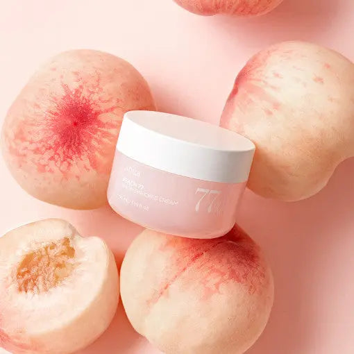 Anua Peach 77 Niacin Enriched Cream 50ml with peaches on pink background.